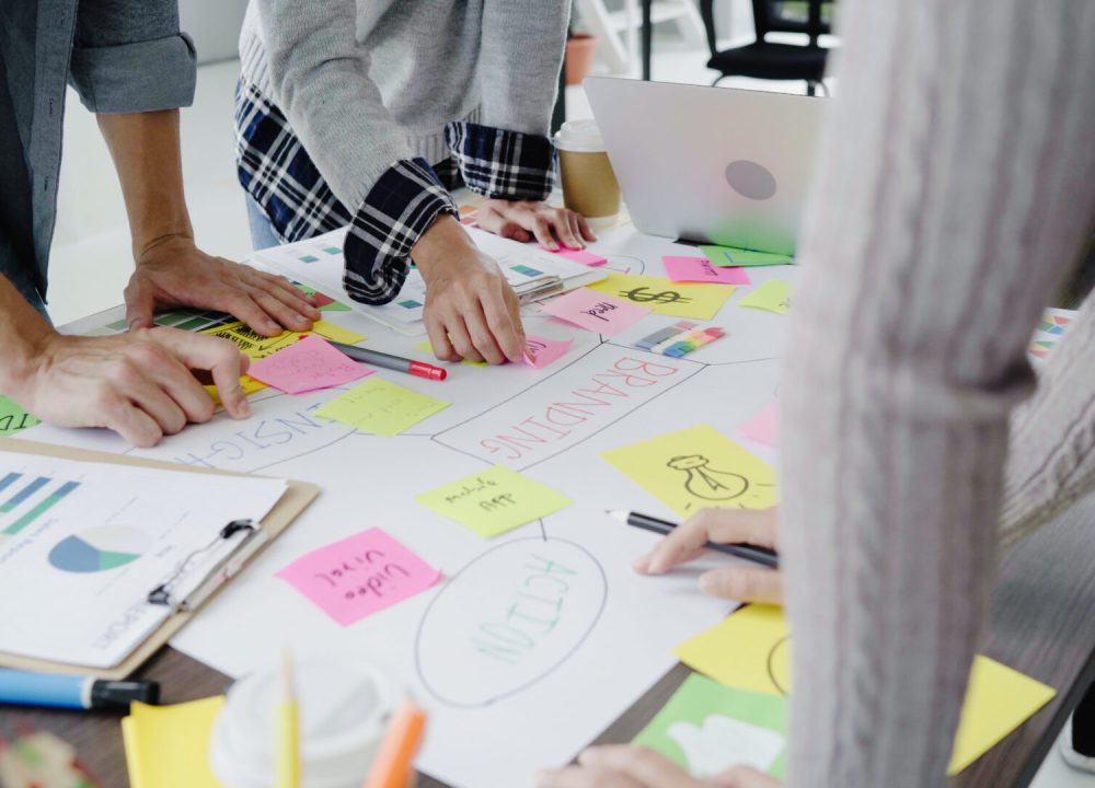 Group of casually dressed business people discussing ideas in the office. Creative professionals gathered at the meeting table for discuss the important issues of the new successful startup project.